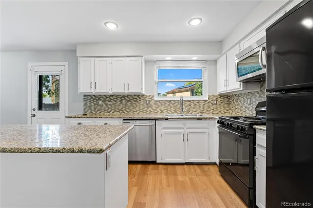 a kitchen with a stove and wooden floor
