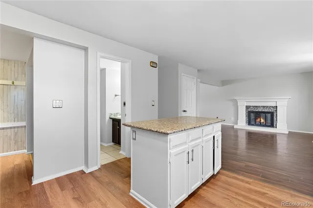 a large kitchen with granite countertop a sink and cabinets