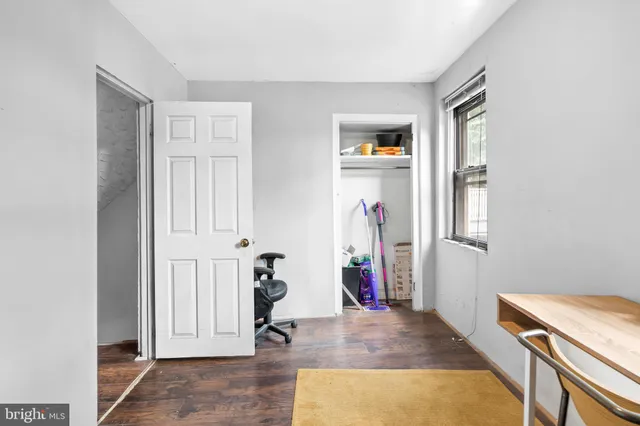 a view of a livingroom with wooden floor and bathroom