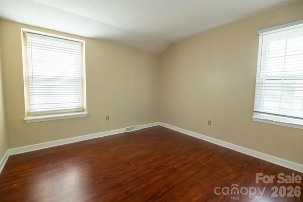 a view of a room with wooden floor and windows
