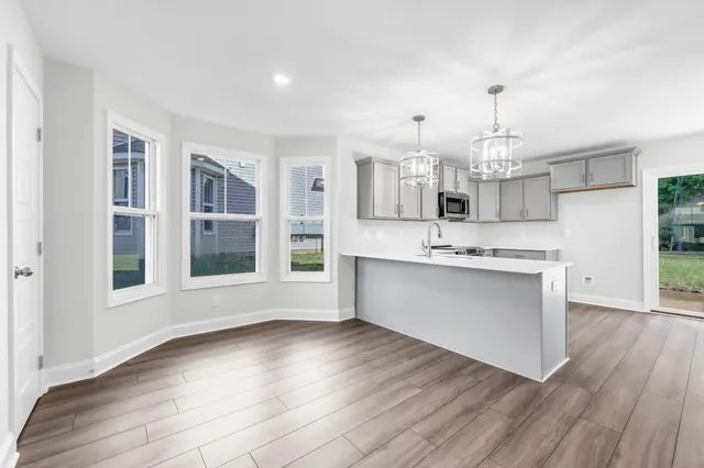 a view of large kitchen with granite countertop white cabinets and wooden floor