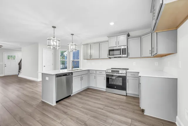 a kitchen with granite countertop white cabinets and stainless steel appliances