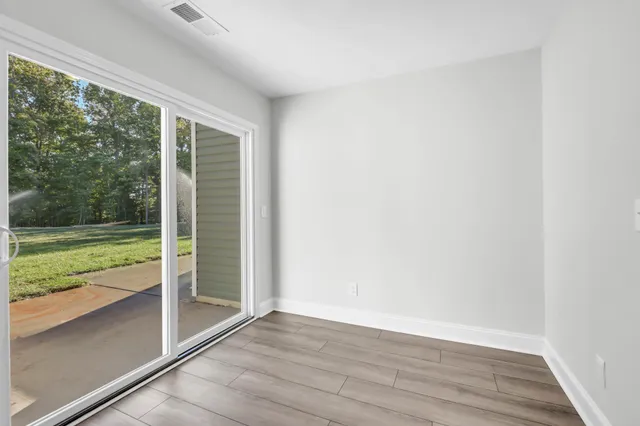 a view of a room with wooden floor and a lake view