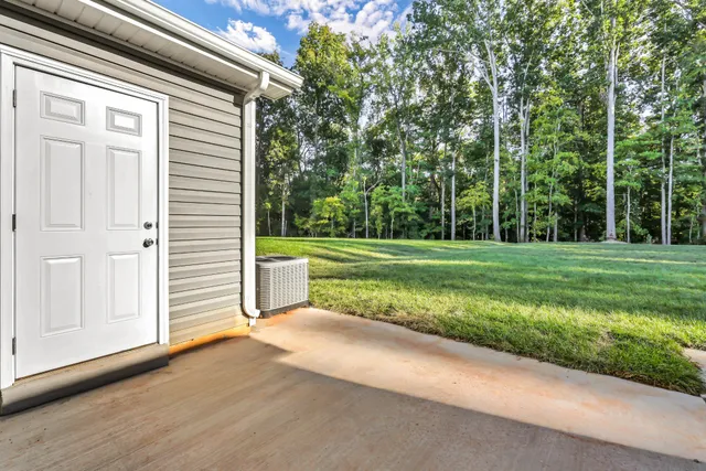 a view of a house with backyard and trees
