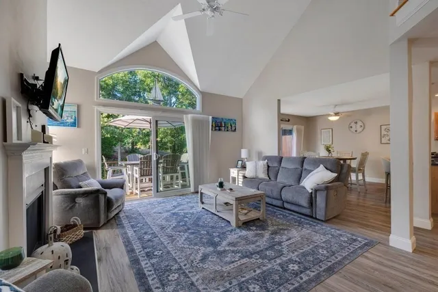 a living room with furniture a large window and a flat screen tv