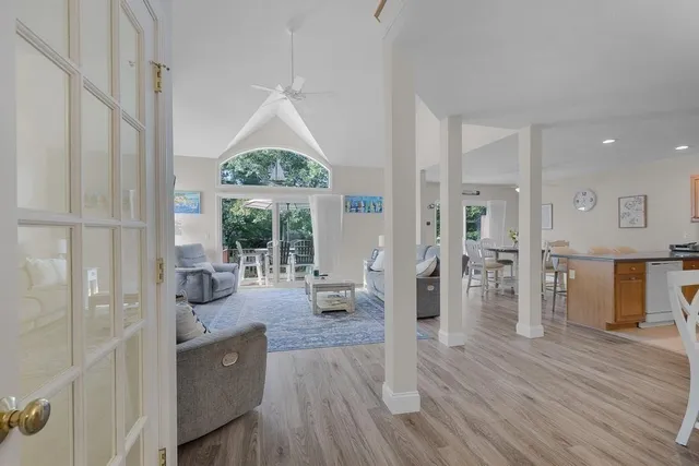 a living room with furniture large window and wooden floor