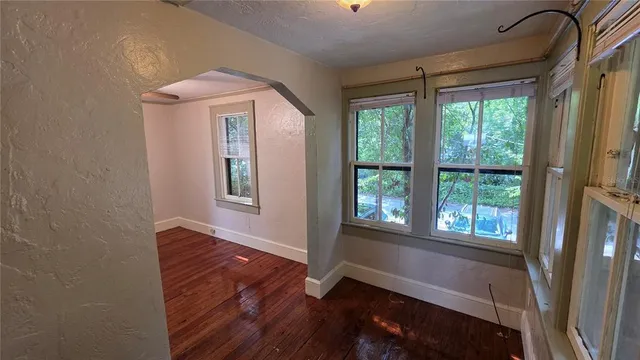 a view of hallway with a large window and wooden floor