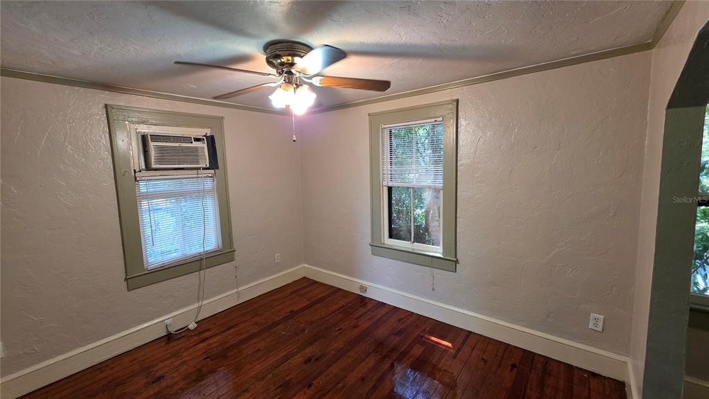 1317 Northwest 7th Avenue Gainesville, FL 32603 - Photo 6 of 10 a view of an empty room with wooden floor and a window