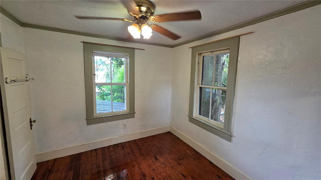 1317 Northwest 7th Avenue Gainesville, FL 32603 - Photo 7 of 10 a view of an empty room with a window and wooden floor