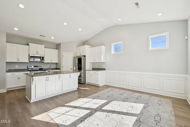 a large white kitchen with cabinets and stainless steel appliances