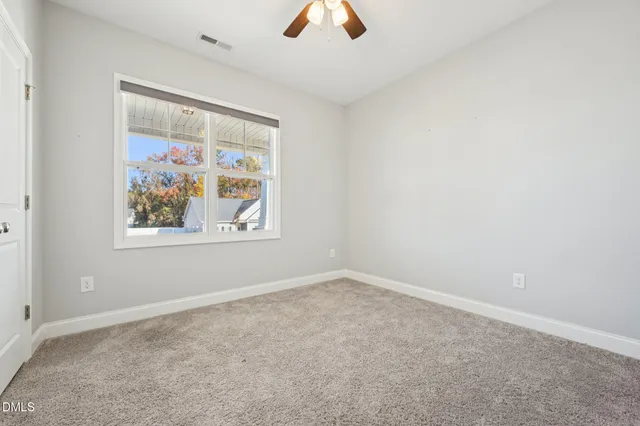 an empty room with a window and a ceiling fan