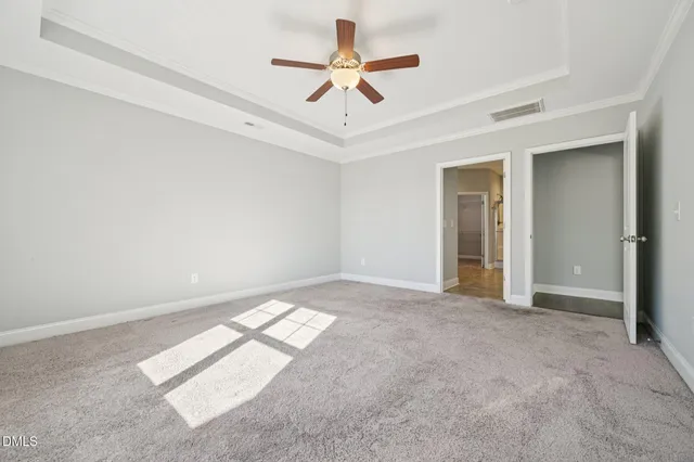 an empty room with fan and windows