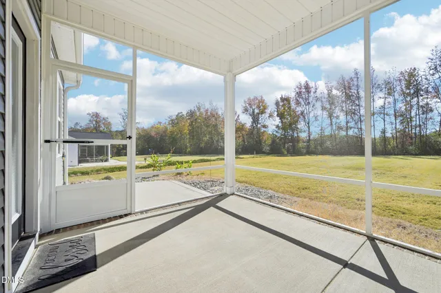 a view of an empty room with a window and hardwood