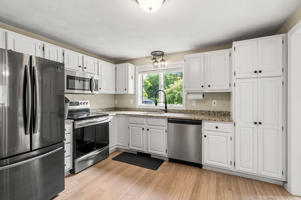 28 Andrews Farm Road Boxford, MA 01921 - Photo 10 of 42 a kitchen with granite countertop a refrigerator sink and white cabinets
