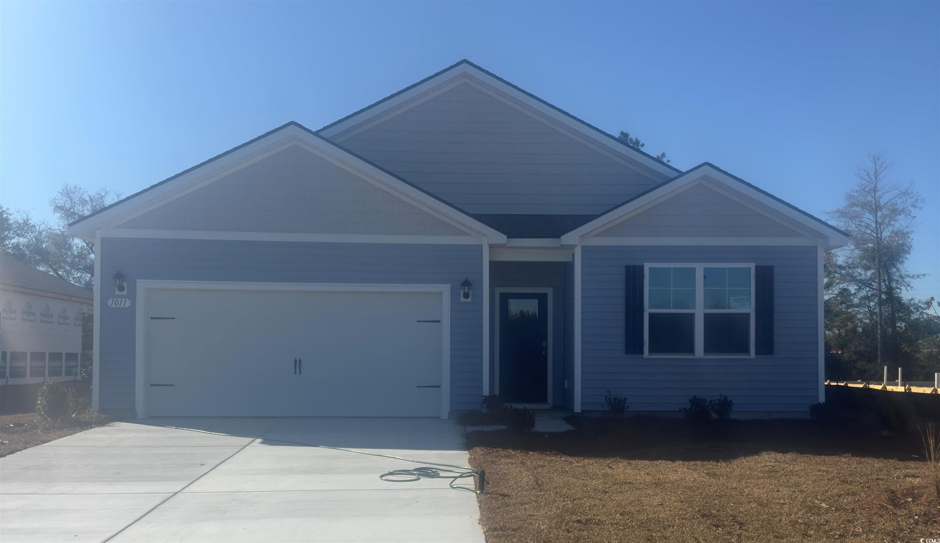 View of front of home featuring a garage and concrete driveway