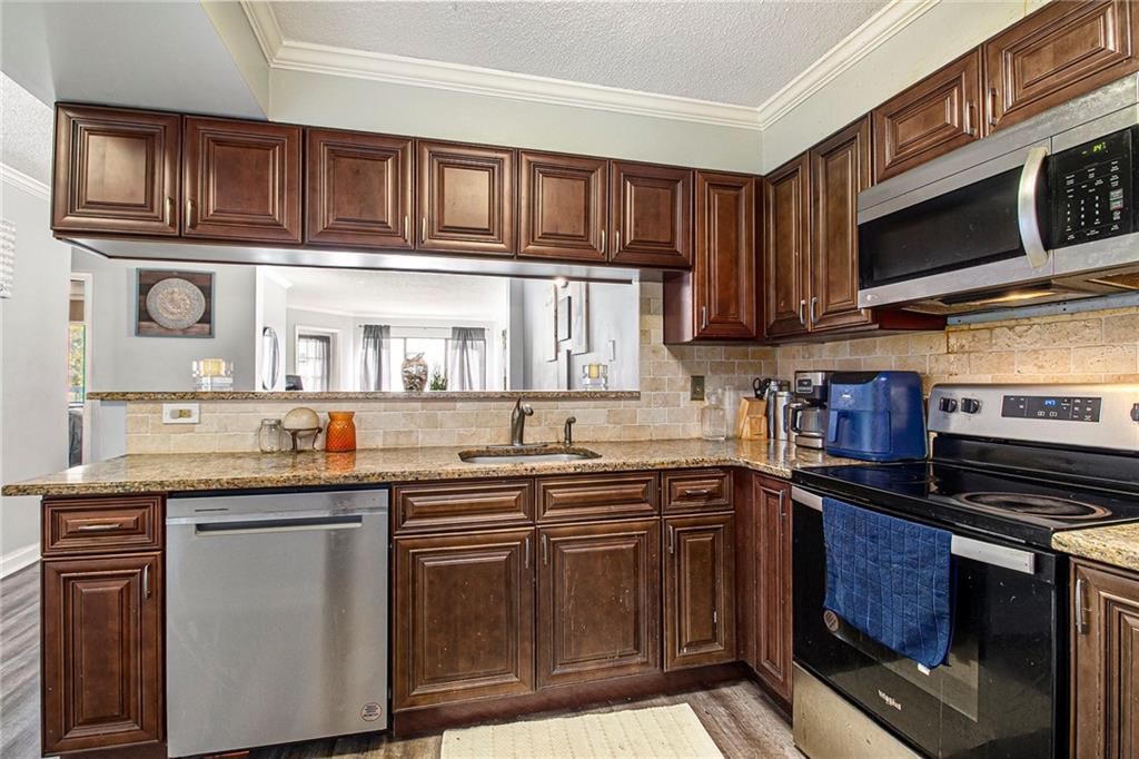 795 Hammond Drive, Unit 206 Atlanta, GA 30328 - Photo 11 of 29 a kitchen with stainless steel appliances granite countertop a stove sink microwave and cabinets
