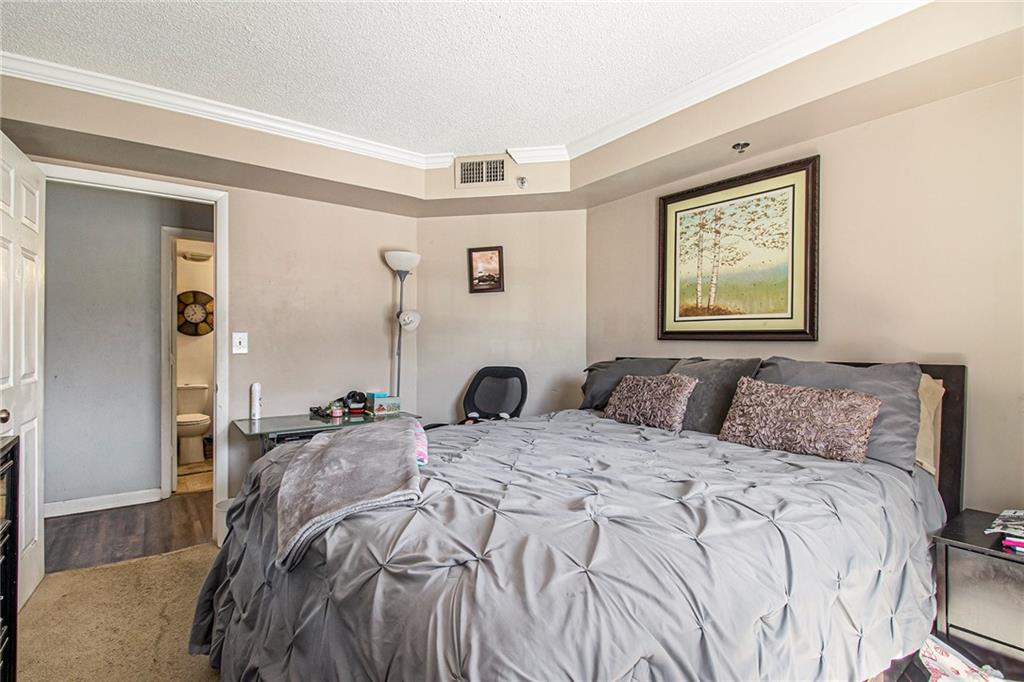 795 Hammond Drive, Unit 206 Atlanta, GA 30328 - Photo 14 of 29 a bedroom with a bed and a window