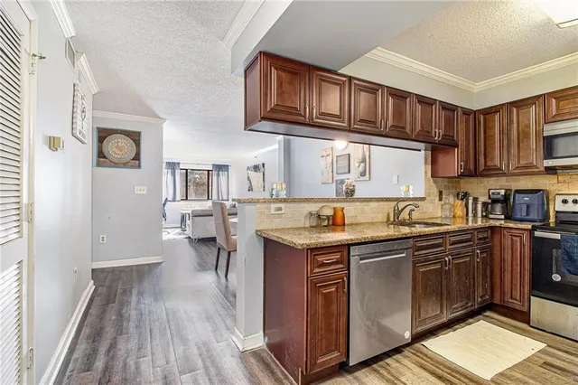 a kitchen with stainless steel appliances granite countertop a refrigerator stove a sink and a granite counter tops