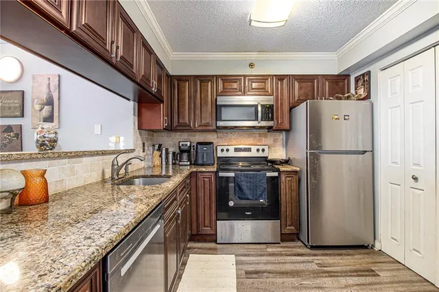a kitchen with stainless steel appliances granite countertop a stove sink microwave and cabinets