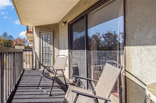 a view of a hallway with wooden floor and a bathroom
