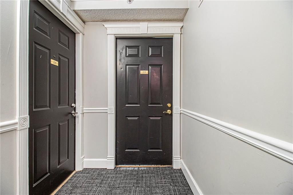 795 Hammond Drive, Unit 206 Atlanta, GA 30328 - Photo 20 of 29 a view of a hallway with wooden floor and a bathroom