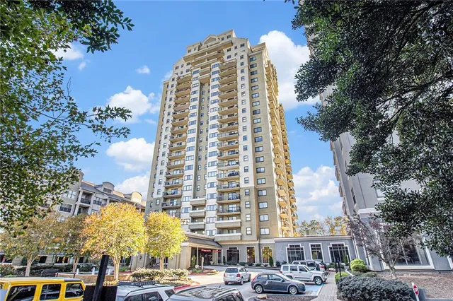 a view of a buildings with lot of cars parked in front of it
