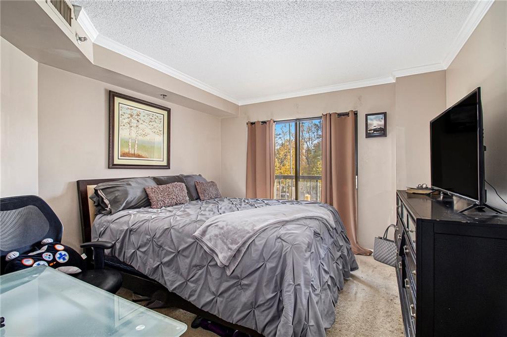 795 Hammond Drive, Unit 206 Atlanta, GA 30328 - Photo 27 of 29 a bedroom with a bed and a flat screen tv