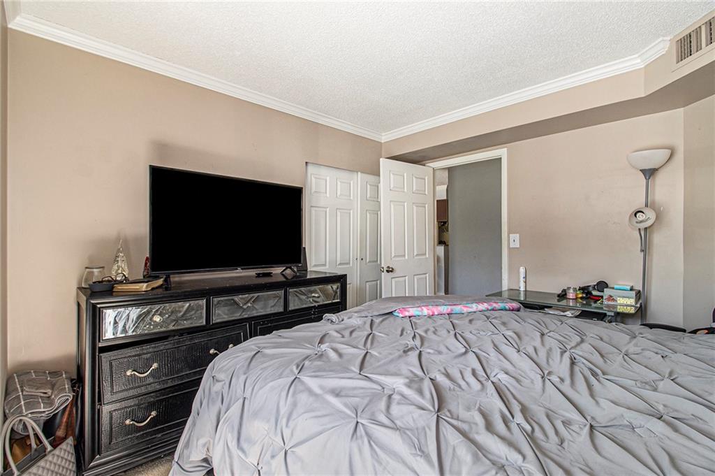 795 Hammond Drive, Unit 206 Atlanta, GA 30328 - Photo 28 of 29 a bedroom with a bed and a flat screen tv