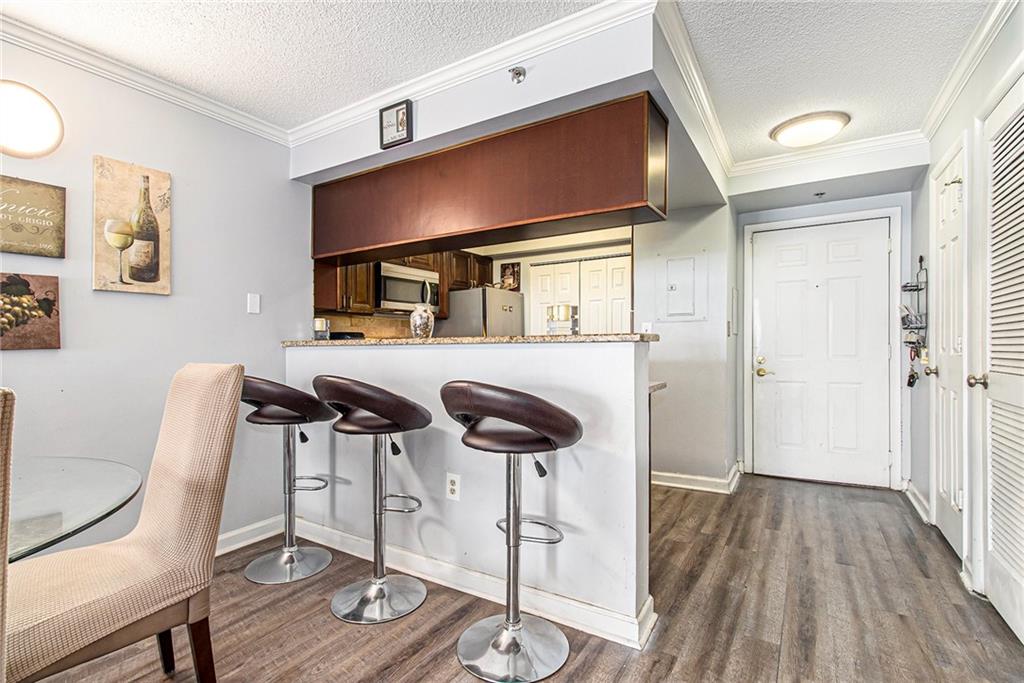 795 Hammond Drive, Unit 206 Atlanta, GA 30328 - Photo 5 of 29 a kitchen with stainless steel appliances a dining table chairs and wooden floor