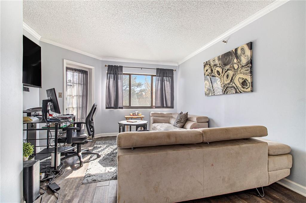 795 Hammond Drive, Unit 206 Atlanta, GA 30328 - Photo 6 of 29 a living room with furniture and a flat screen tv