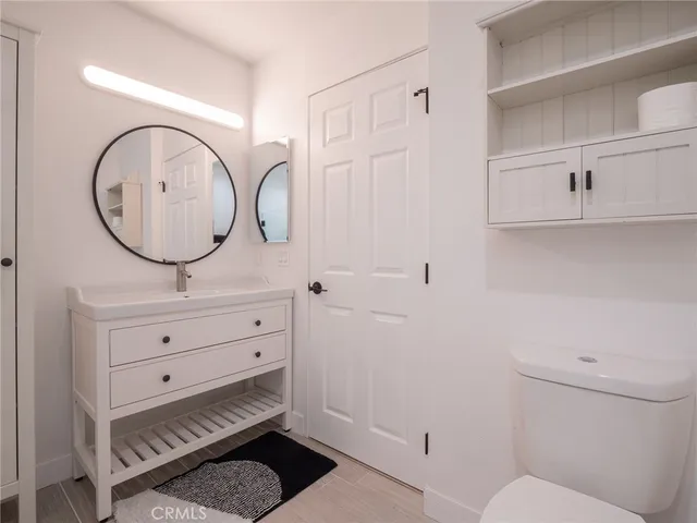 a bathroom with a toilet a sink and mirror