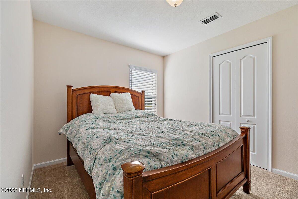 120 Toscana Lane St. Augustine, FL 32092 - Photo 16 of 29 a bedroom with a bed and mirror
