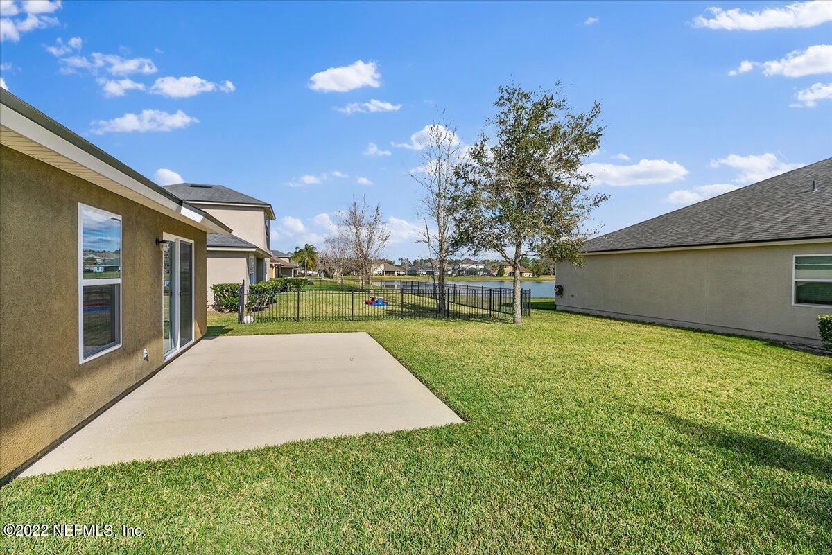 120 Toscana Lane St. Augustine, FL 32092 - Photo 18 of 29 a view of a backyard with table and chairs with wooden fence