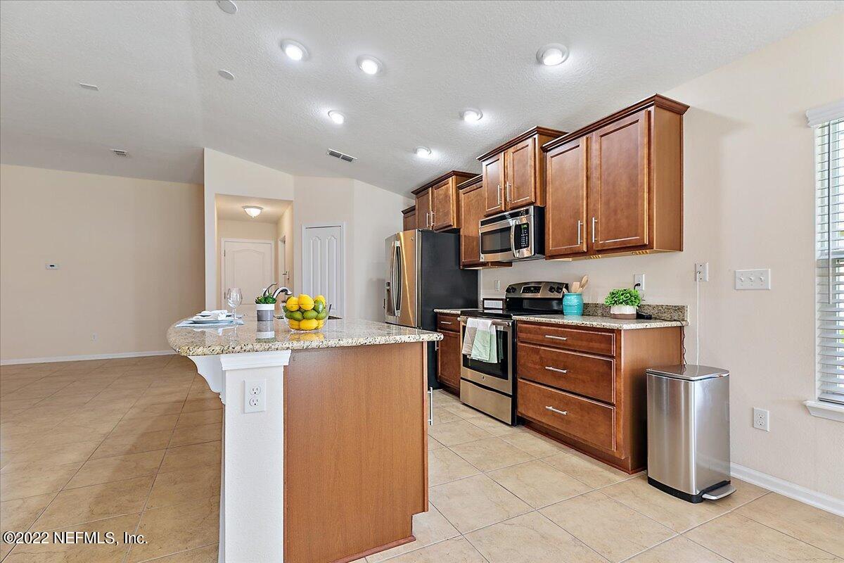 120 Toscana Lane St. Augustine, FL 32092 - Photo 7 of 29 a kitchen with stainless steel appliances granite countertop a stove top oven a sink and a refrigerator