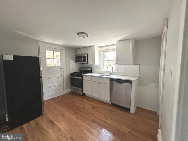 a kitchen with a sink cabinets stainless steel appliances and a window