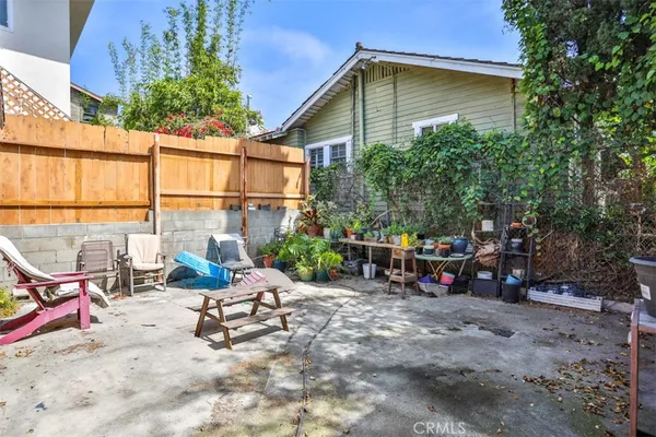 a view of backyard with a table and chairs and potted plants