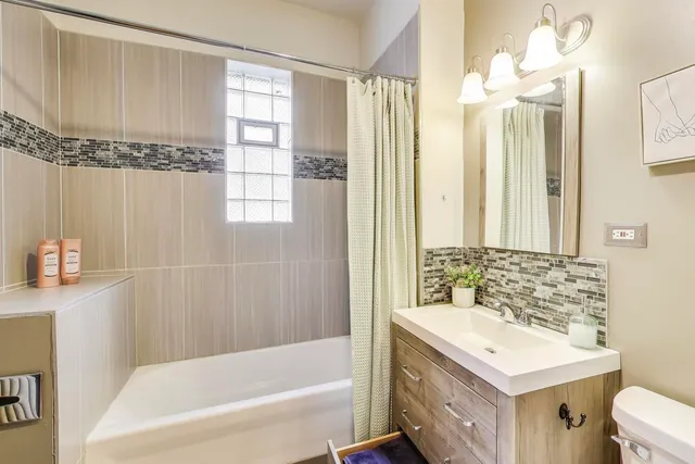 a bathroom with a sink vanity mirror and a bathtub