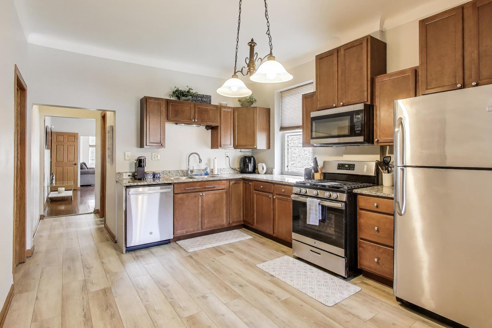 2720 West Polk Street, Unit 1 Chicago, IL 60612 - Photo 8 of 13 a kitchen with stainless steel appliances granite countertop a refrigerator a stove top oven a sink and dishwasher
