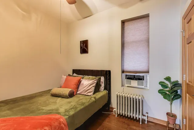 a bedroom with a bed and a potted plant