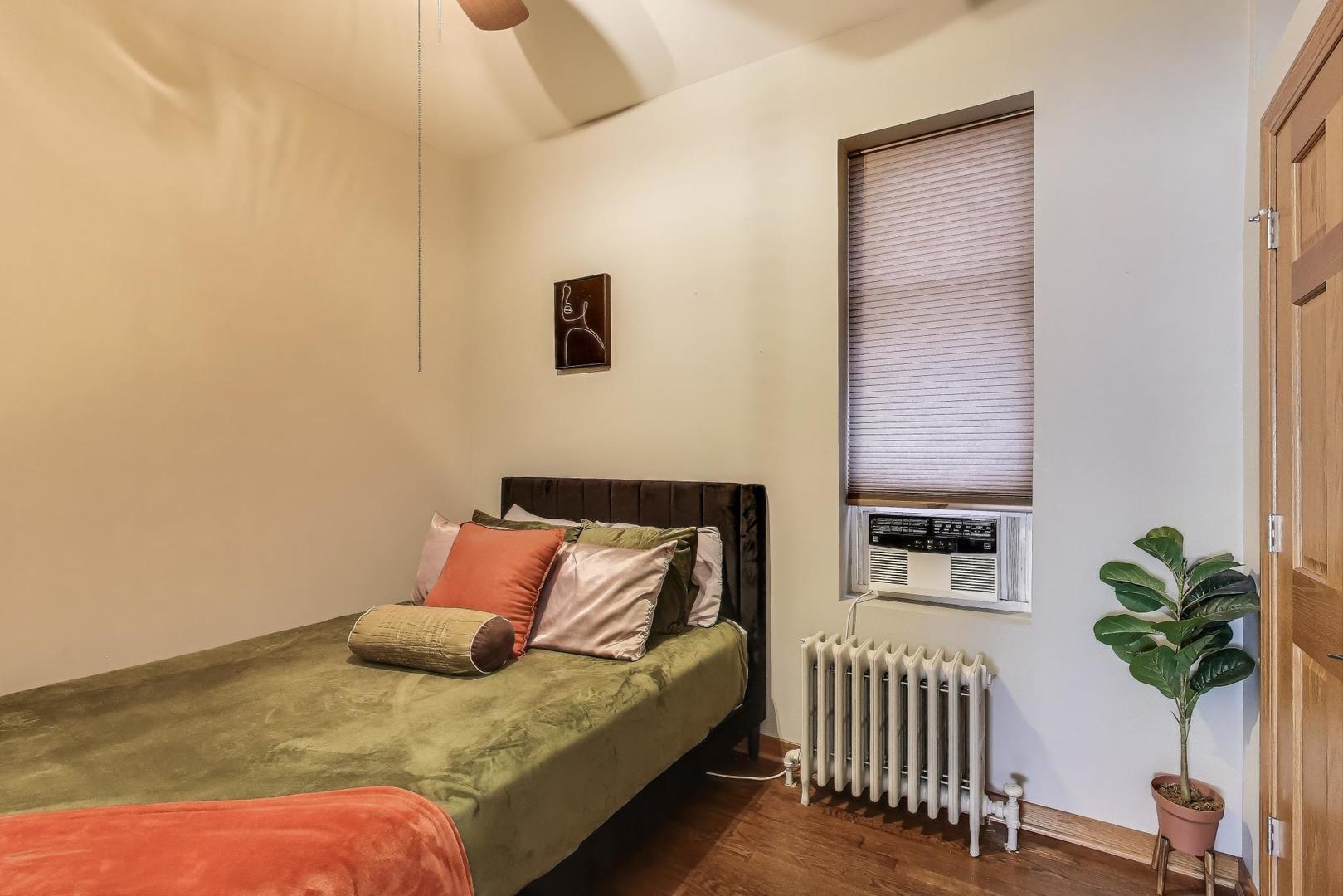 2720 West Polk Street, Unit 1 Chicago, IL 60612 - Photo 9 of 13 a bedroom with a bed and a potted plant