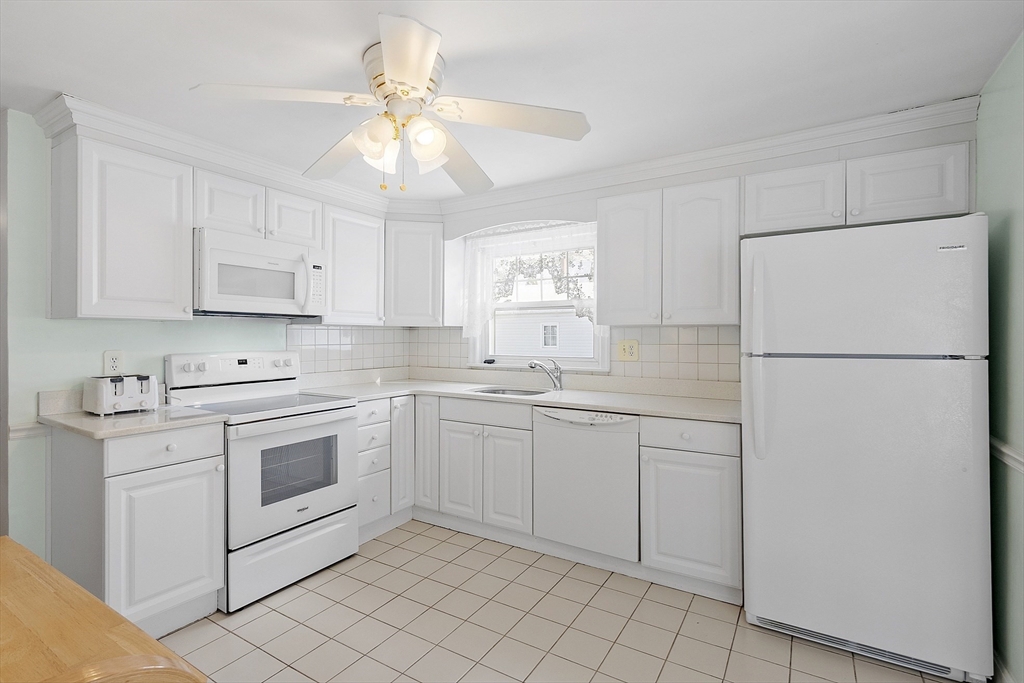 18 Frank Street Chelmsford, MA 01863 - Photo 13 of 38 a kitchen with white cabinets and white appliances