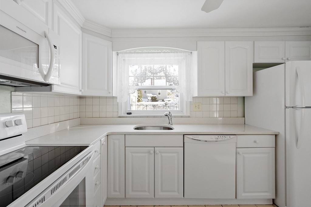 18 Frank Street Chelmsford, MA 01863 - Photo 14 of 38 a kitchen with white cabinets and white appliances