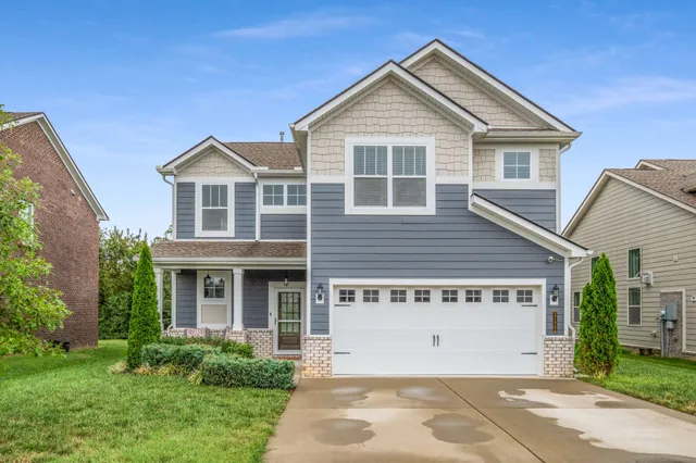 a front view of a house with a garden and plants
