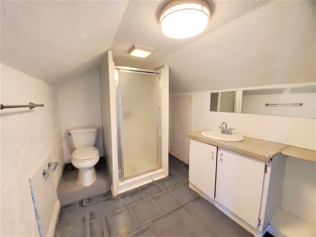 2223 North Locust Street Denton, TX 76209 - Photo 26 of 33 a bathroom with a granite countertop sink a toilet and a large mirror
