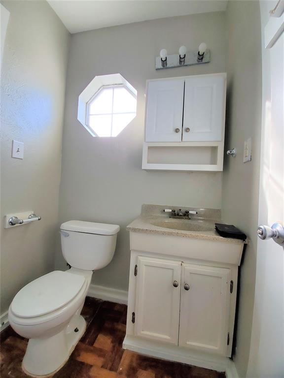 2223 North Locust Street Denton, TX 76209 - Photo 28 of 33 a bathroom with a toilet a sink and mirror
