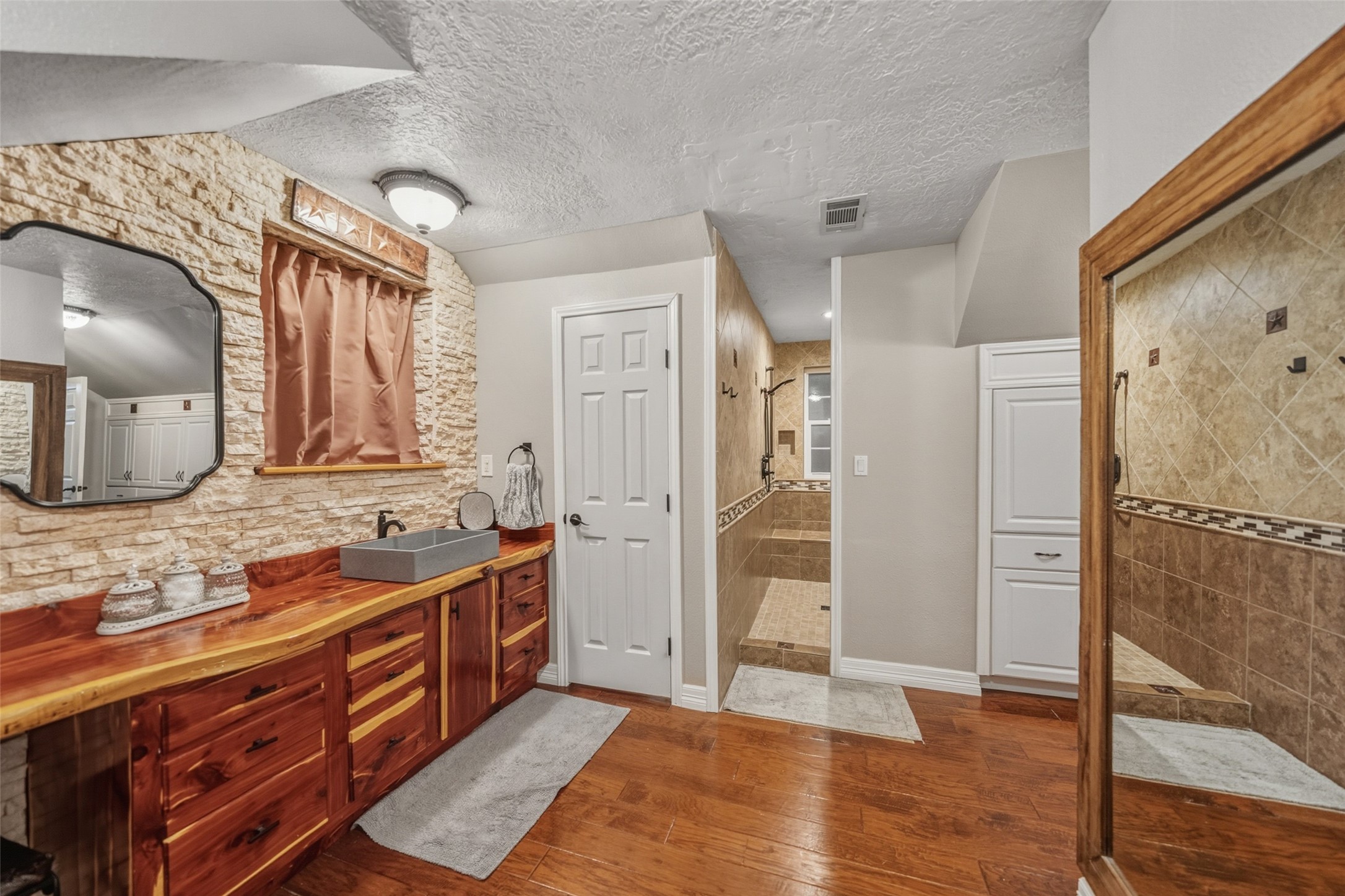 19989 Meadow Bend Road Hempstead, TX 77445 - Photo 22 of 35 Primary bathroom vanity features stone accents, wood cabinetry, and a custom sink for a distinctive, upgraded feel.