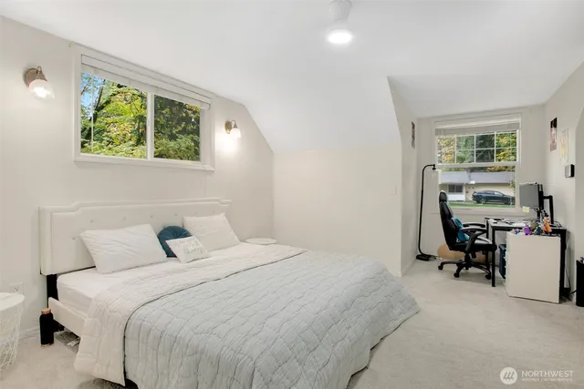 a bedroom with a bed and a table in it with window