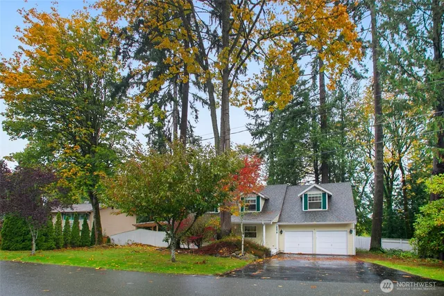a front view of a house with a yard and large trees