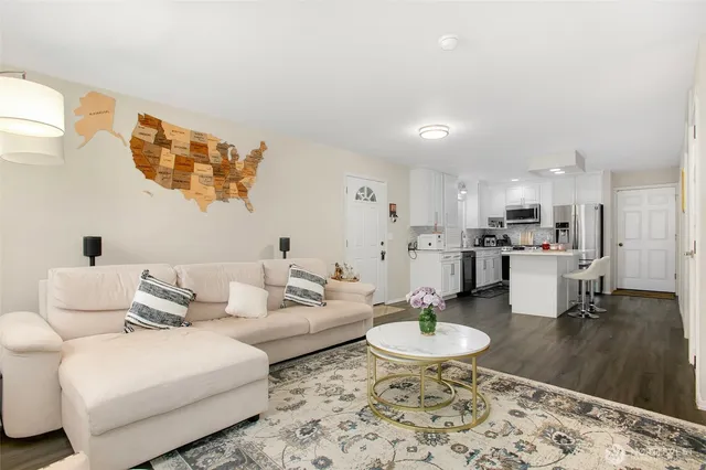 a living room with furniture and a dining table with wooden floor