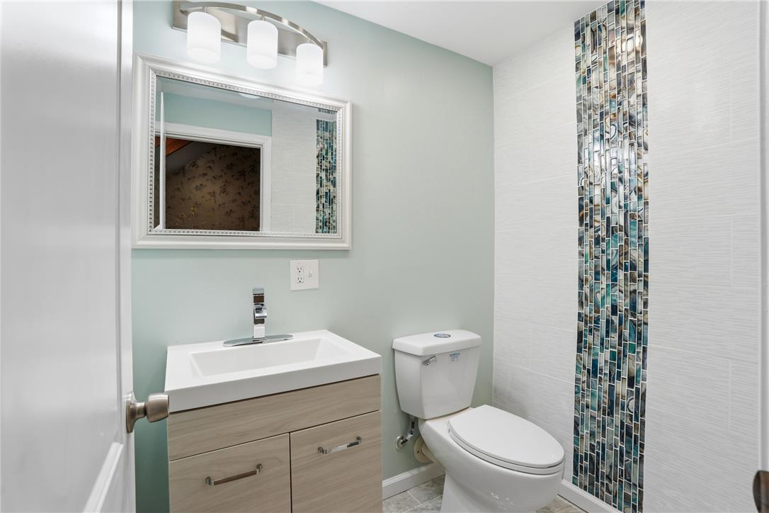6271 Batman Road Zionsville, PA 18092 - Photo 26 of 100 A well-appointed bathroom features a sleek vanity, modern toilet, and a striking mosaic tile accent.